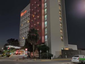 a tall building with a fire truck parked in front of it at Ibis Culiacan in Culiacán