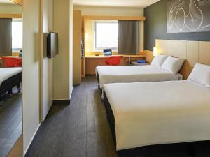 a hotel room with two beds and a desk at Ibis Culiacan in Culiacán +96 photos
