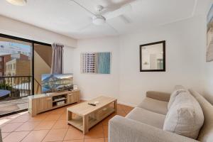 a living room with a couch and a tv at Nautilus Resort - Private Apartment in Mooloolaba