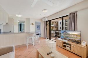 a kitchen and a living room with a flat screen tv at Nautilus Resort - Private Apartment in Mooloolaba