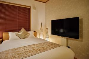 a bedroom with a bed and a flat screen tv at R STAY Nagoya Juocho in Nagoya