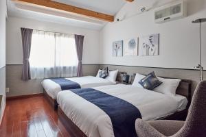 two beds in a hotel room with a window at R STAY Nagoya Juocho in Nagoya