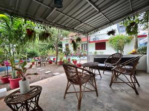 an outdoor patio with chairs and tables and plants at Remasailam Homestay - Thiruvananthapuram , Calm & Blend with Nature in Trivandrum