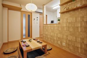 a living room with a table and a wall at R STAY Nagoya Juocho in Nagoya