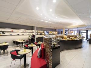 a restaurant with tables and chairs and a bar at Mercure Hotel Düsseldorf Zentrum in Düsseldorf