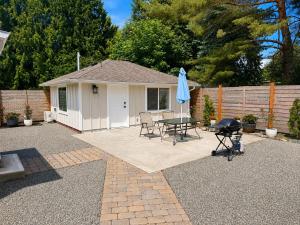 a patio with a table and a grill and a house at Modern Private Studio - Separate Entry in Edgewood