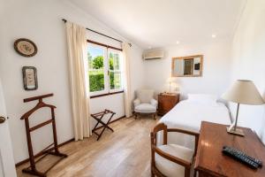 a bedroom with a bed and a desk and a table at Hotel Casagrande in Paysandú +19 photos