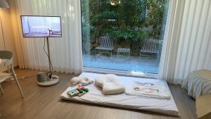 a room with a bed with two stuffed animals and a television at South Sagye Jeju in T'ogi-dong +109 photos