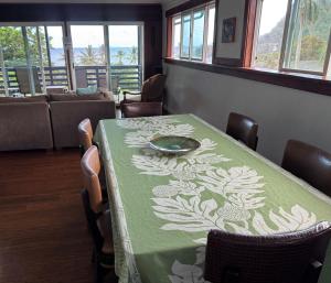 a dining room with a table with a green table cloth at Pau Hana Paradise in Hana
