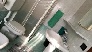 y baño con aseo blanco y lavamanos. en Ristorante Albergo Roma, en Legnano