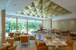 a restaurant with tables and chairs and a ceiling at Hotel El Dorado Bogota in Bogotá