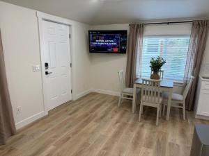 a dining room with a table and a television on the wall at Modern Private Studio - Separate Entry in Edgewood