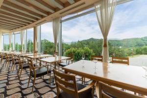 a row of tables and chairs in a room with windows at Hilton Takayama Resort in Takayama