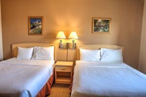 a hotel room with two beds and two lamps at Lone Star Hotel in North Battleford +18 photos