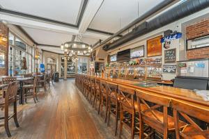 a bar in a restaurant with wooden tables and chairs at Bedford Regency Hotel, Trademark Collection by Wyndham in Victoria