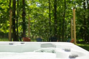 a white bath tub sitting on top of a table at Tucked in the Woods - Jacuzzi Firepit Pooltable in Long Pond +46 photos