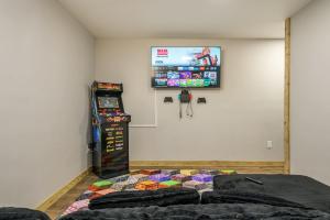 a room with two beds and a tv on the wall at Tucked in the Woods - Jacuzzi Firepit Pooltable in Long Pond