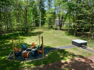 an overhead view of a backyard with a grill and chairs at Tucked in the Woods - Jacuzzi Firepit Pooltable in Long Pond