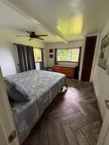 a bedroom with a bed and a ceiling fan at Hana Homestead in Hana