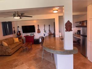 a living room with a table and a living room with guitars at Hana Homestead in Hana +14 photos