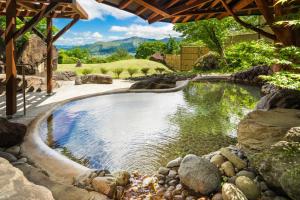 a pool of water in a yard with rocks at La Vista Minami Aso Grand opening October 2nd 2026 in Minami Aso +42 photos