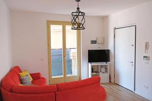 a living room with a red couch and a television at Lake Iseo Apartment - Taxo4 in Paratico