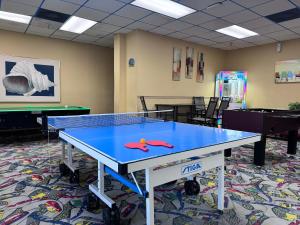 a ping pong table in a room with ping pong balls on it at Cuddle's Comfort & OCEAN in Daytona Beach