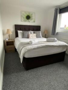 a bedroom with a large bed with two night stands at Pure Home Oakley Central TBA in Dunfermline