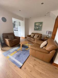 a living room with two couches and a rug at Pure Home Oakley Central TBA in Dunfermline
