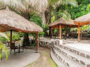a patio with umbrellas and a table and chairs at Pullman Kinshasa Grand Hotel in Kinshasa