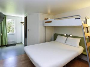 a bedroom with a bed with a bunk bed at Ibis budget Lorient Caudan in Caudan