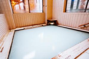 a bathroom with a bath tub in a tiled room at ZAO SPA HOTEL Kiraku in Zaō Onsen +18 photos