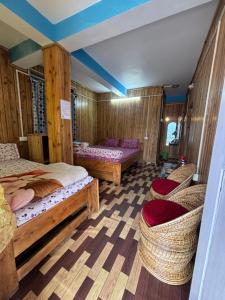a bedroom with two beds and wicker chairs at Shivaay Inn in Lava +12 photos