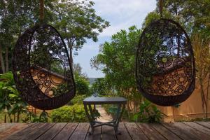 two baskets hanging from a wooden deck with a stool at Samloem Laguna Resort in Koh Rong Sanloem