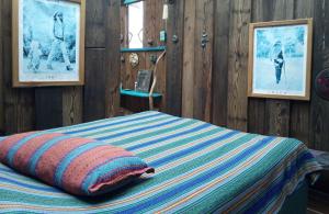 a bed with a striped comforter in a room at Kismet Inn Semi Private in Hopkins