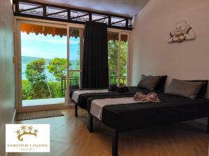 two beds in a room with a large window at Samloem Laguna Resort in Koh Rong Sanloem