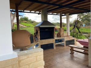 a patio with an outdoor oven and a bench at Casa - Finca Villa Violeta in San Vicente