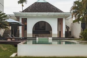 a villa with a swimming pool in front of a house at Nara Villa Canggu by Ini Vie Hospitality in Canggu