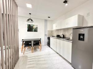 a kitchen with a table and a dining room at Vela Villa Apart N3 in Villa Ángela