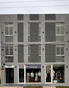 a gray building with people standing in the windows at Vela Villa Apart N3 in Villa Ángela +16 photos