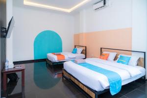 a bedroom with two beds in a room at SANS Hotel Bobo Home Jambi in Jambi