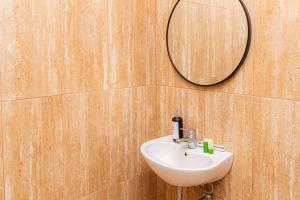 a bathroom with a sink and a mirror on the wall at SANS Hotel Bobo Home Jambi in Jambi +59 photos