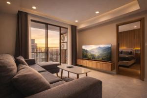 a living room with a couch and a tv at Luxumiere Apartment with Resort Pool - Elite Gym in Ho Chi Minh City