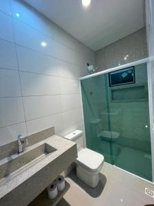 a bathroom with a toilet and a glass shower at Pousada Recanto do Oásis in Triunfo +8 photos