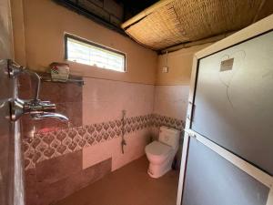 a small bathroom with a toilet and a window at Organic Retreats in Pokhara +14 photos