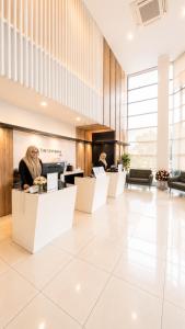 a lobby with a woman sitting at a counter at The Leverage Lite (Kuantan) in Kuantan