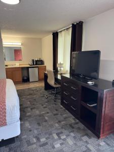 a hotel room with a bed and a flat screen tv at Gateway Inn in Lyman