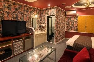 a hotel room with a tv and a bedroom at Hotel WIN in Fukaya