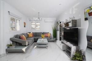 a living room with a couch and a flat screen tv at Moonlit Villa in Planos