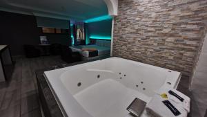 a large white tub in a room with a brick wall at Real La Viga Motel in Mexico City +26 photos